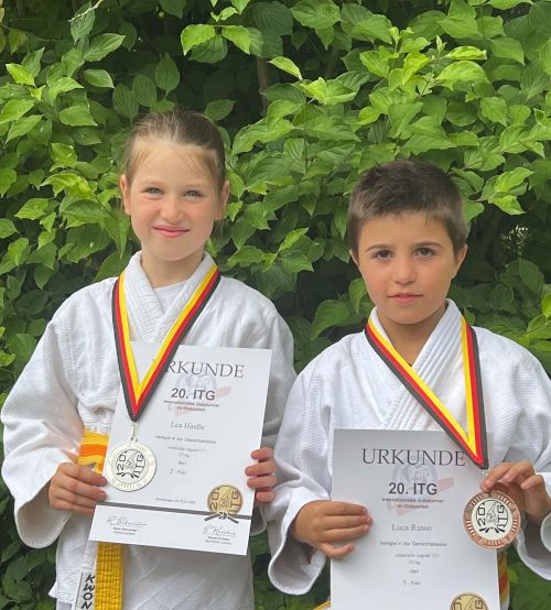 Lea und Luca mit ihren Urkunden und Medaillen